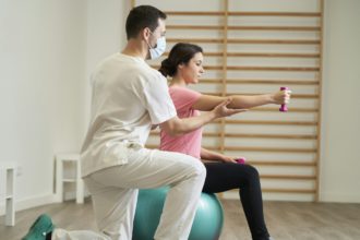 The physiotherapist doing rehabilitation exercises with the patient